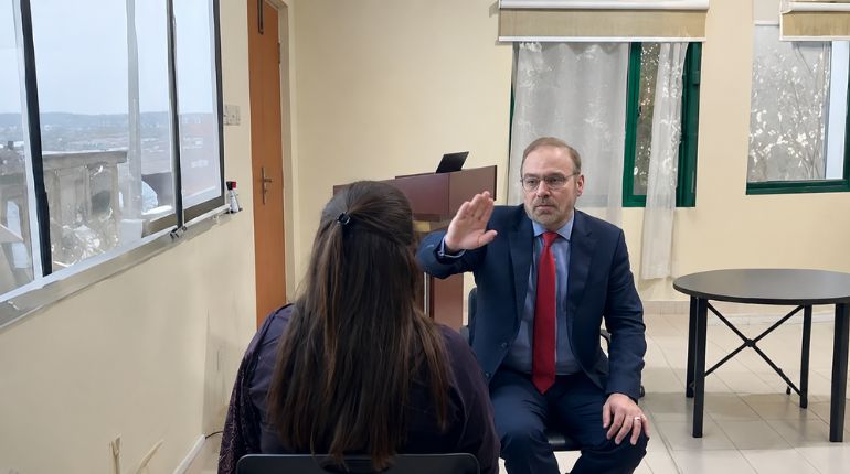 Professional doctor conducting a counseling or therapy session with a female patient in a clinic room.